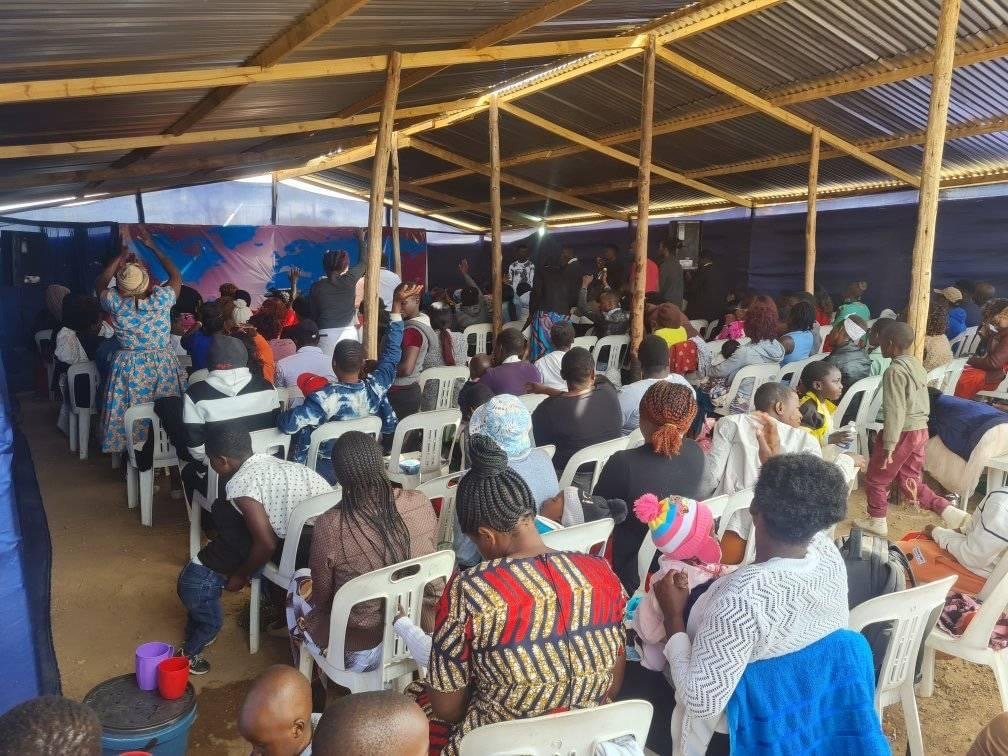 Congregation seated for a service with the worship team performing at the Karoi church
